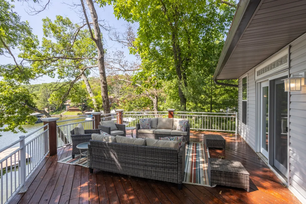 An inviting outdoor seating area with a clear view of the water, set among lush greenery. The area is arranged for both dining and relaxation, ideal for group gatherings or quiet moments immersed in nature.